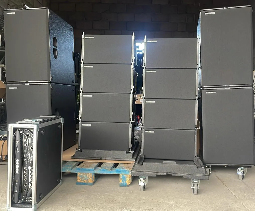 Recintos line array TW Audio VERA10 y subgraves B30 en el almacén, junto a un rack de etapas